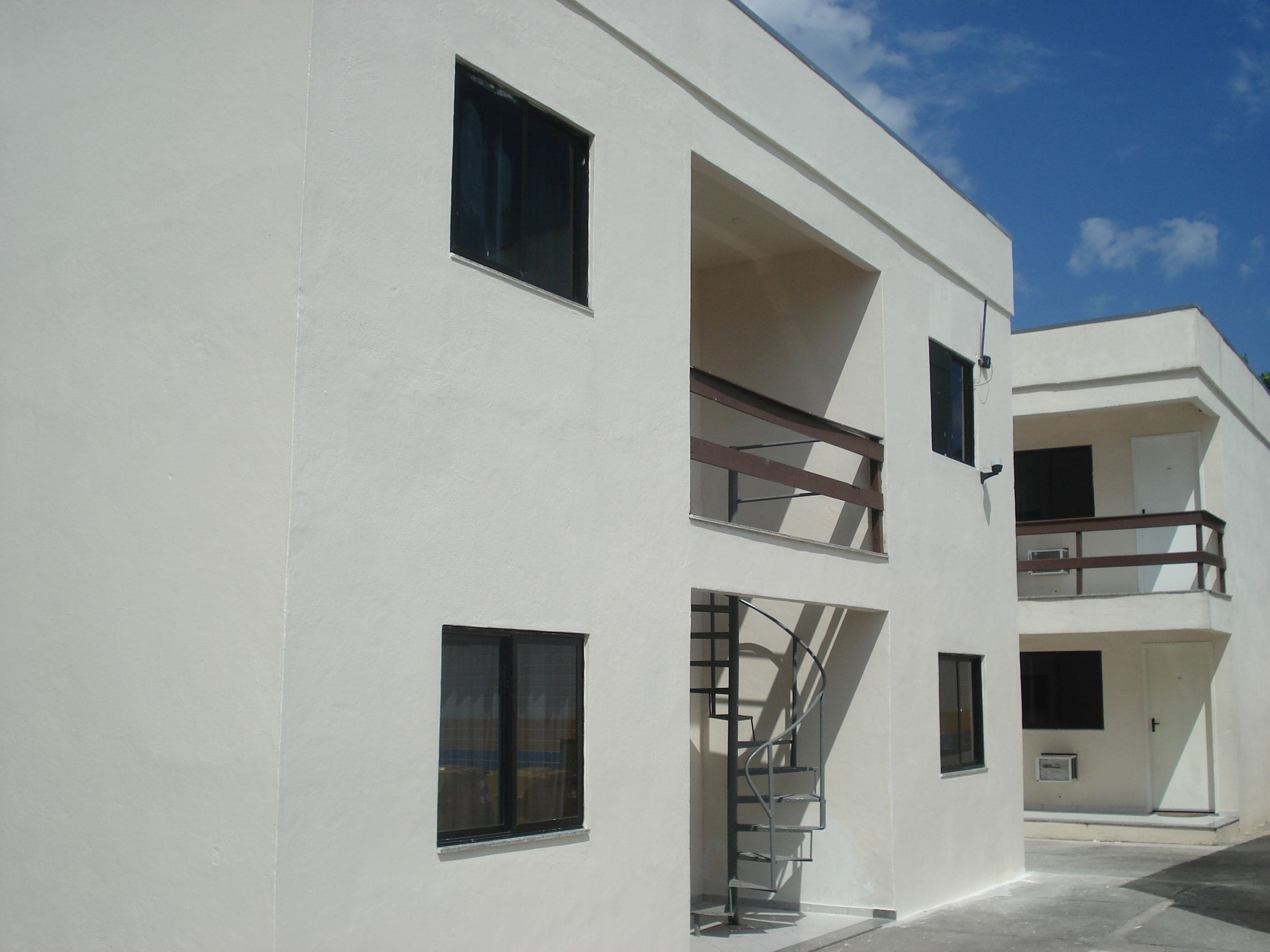 Un edificio moderno con varios balcones y una escalera de caracol.
