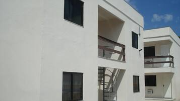 A modern building with multiple balconies and a spiral staircase.