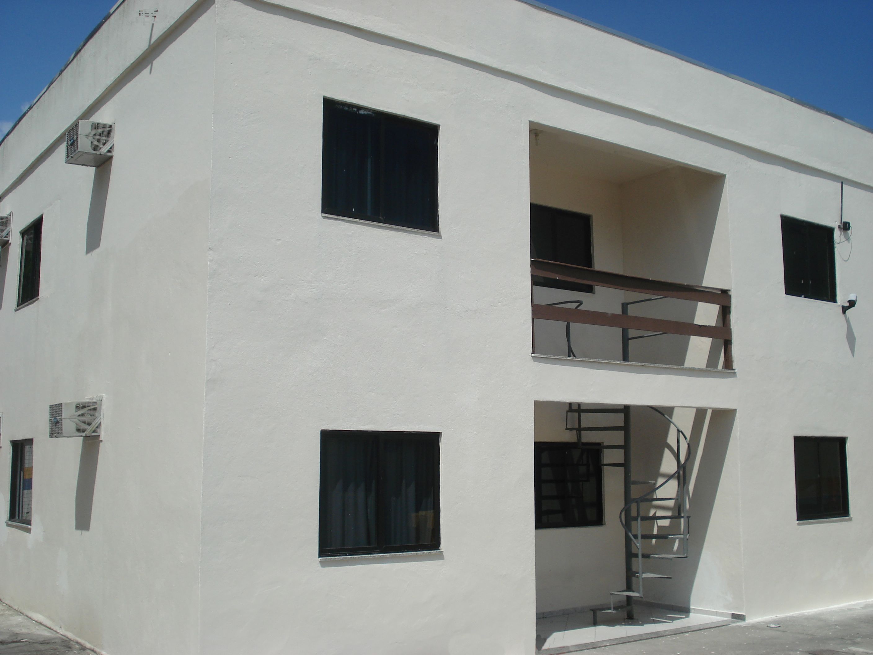 Ένα λευκό κτίριο με πολλά παράθυρα και ένα μπαλκόνι.