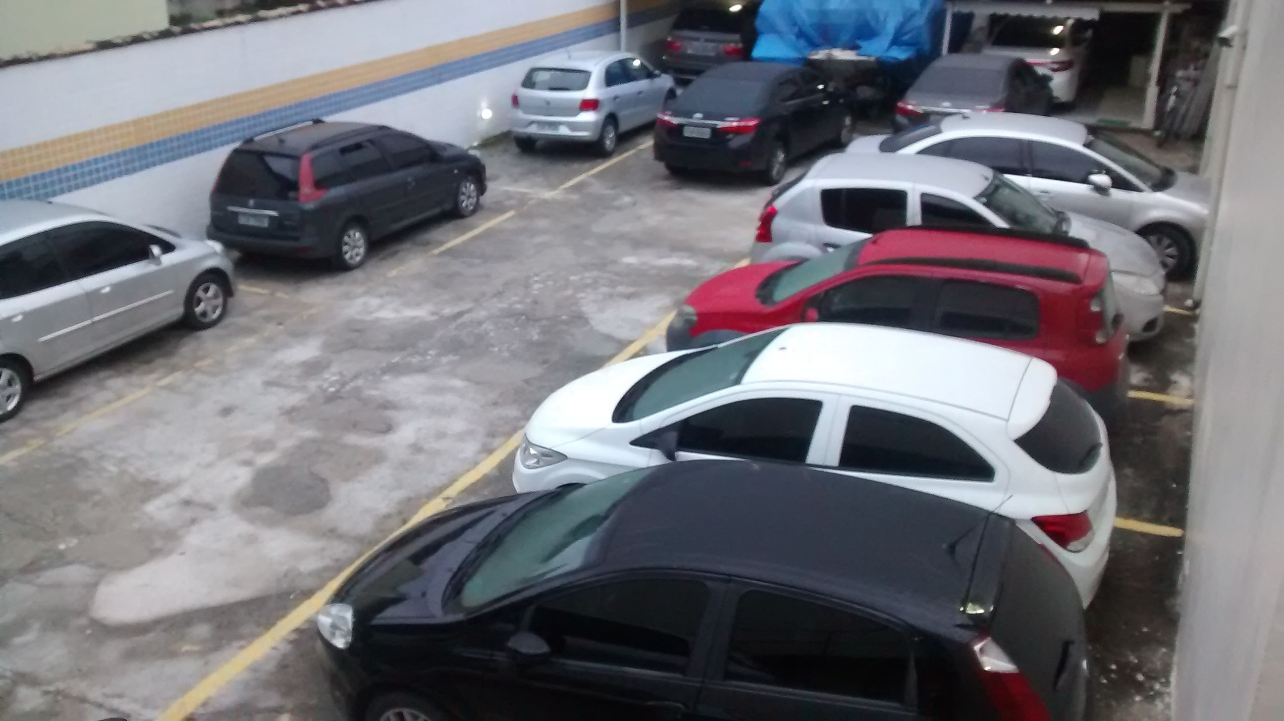 Un estacionamiento con varios coches aparcados en espacios designados.