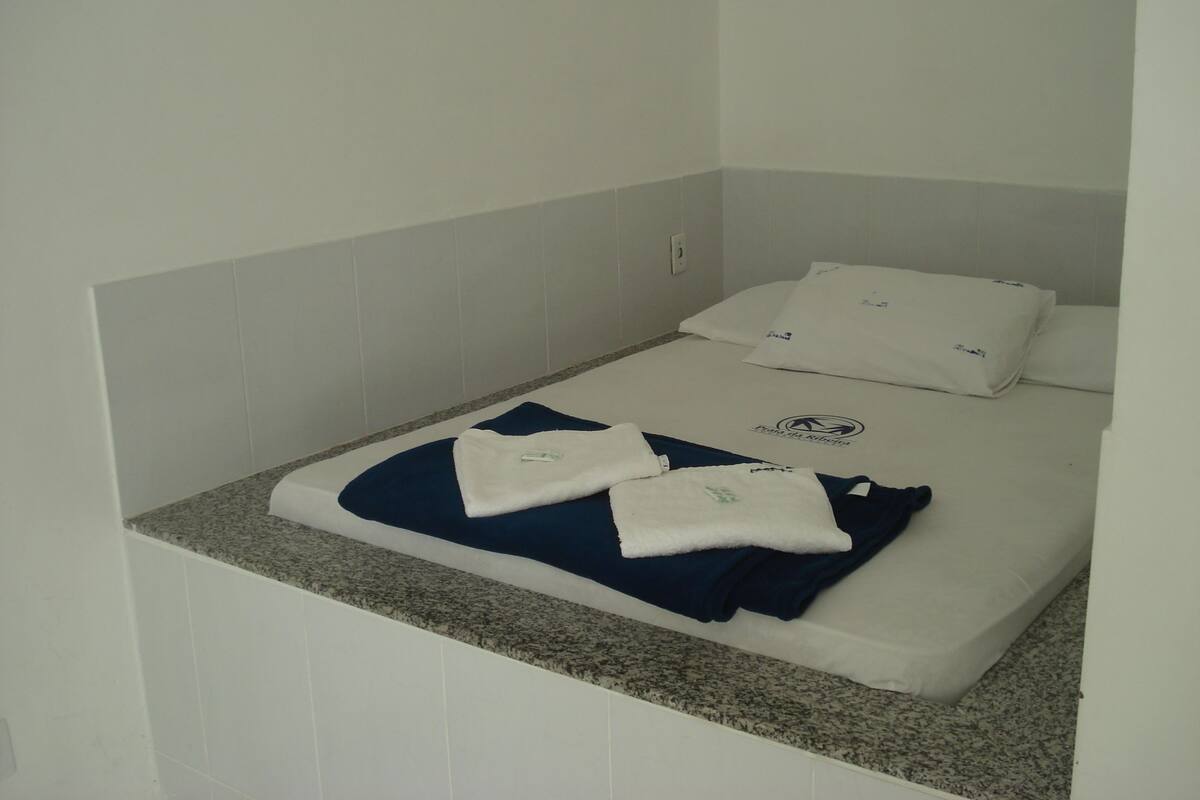 A small, single-bed room with a granite countertop and white walls.