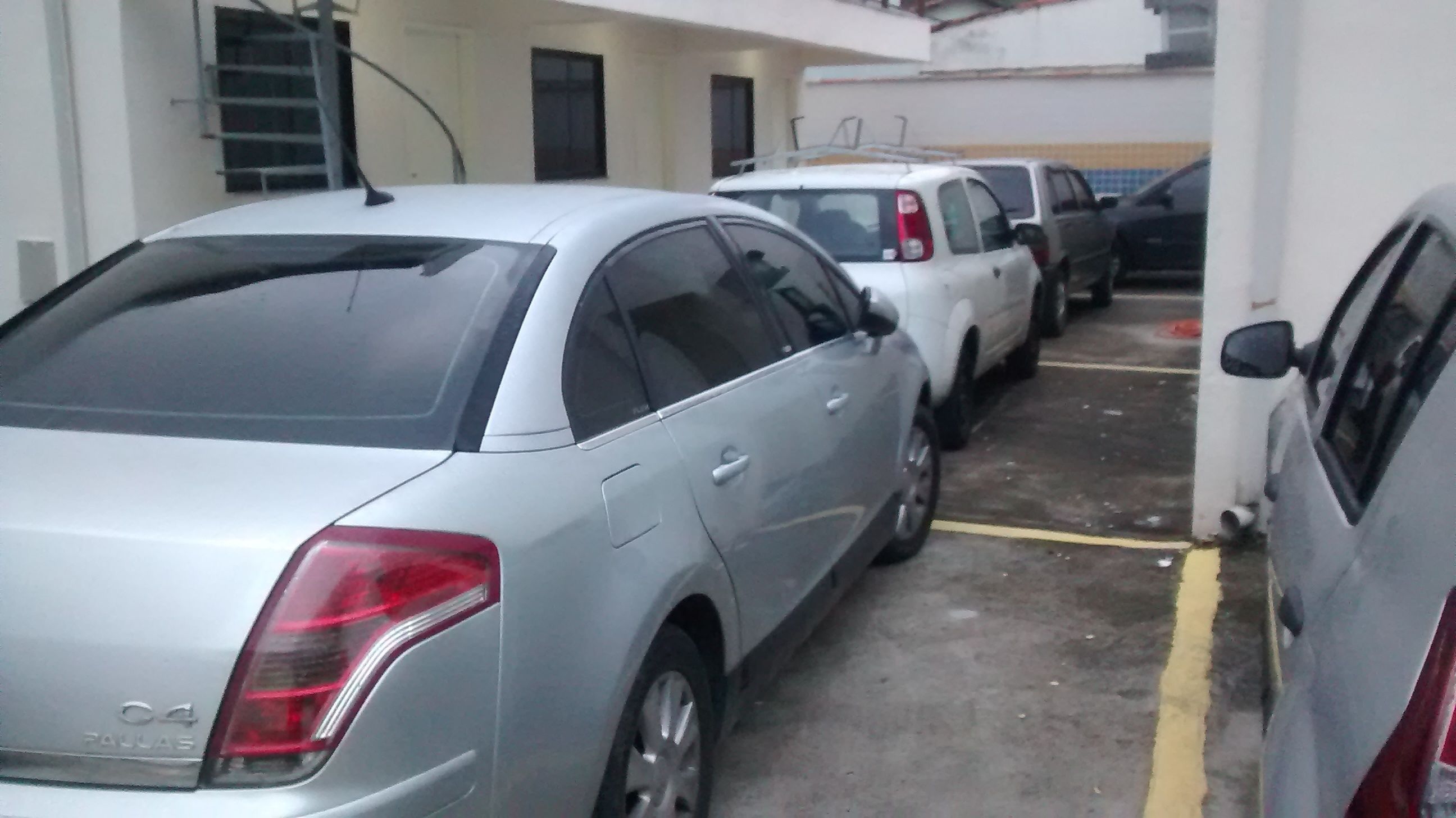 A parking area with several cars, including a silver sedan and a white SUV.