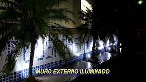 An illuminated exterior wall of a building with a tiled pattern and palm trees. - Pousada Praia da Ribeira Clube (Angra dos Reis)