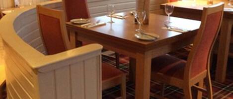 Un comedor con una mesa redonda, sillas y un radiador.