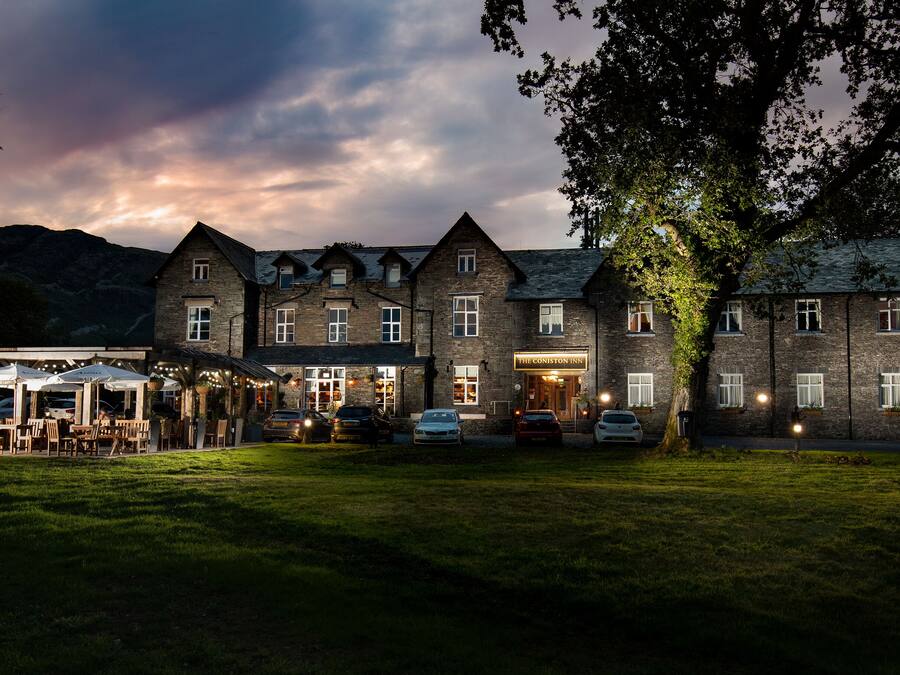 Edifici de pedra amb diverses finestres i un rètol que diu "The Coniston Inn".