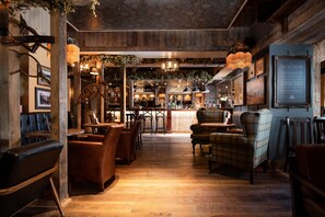 Un restaurante acogedor con suelos de madera, asientos de cuero y una zona de bar.