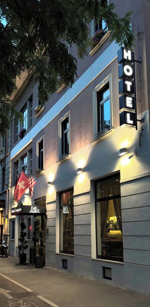 A hotel with a prominent sign, large windows, and a flag. - Hotel Campion CityLife (Milan)