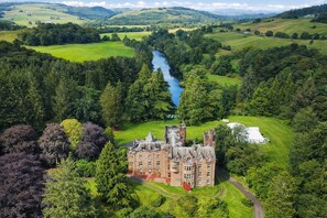 A large, historic building surrounded by lush greenery and a river. - Friars Carse Country House Hotel (Dumfries)