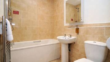 A bathroom with a bathtub, sink, and toilet.
