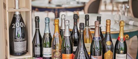 Varias botellas de champán sobre una mesa con mantel floral.