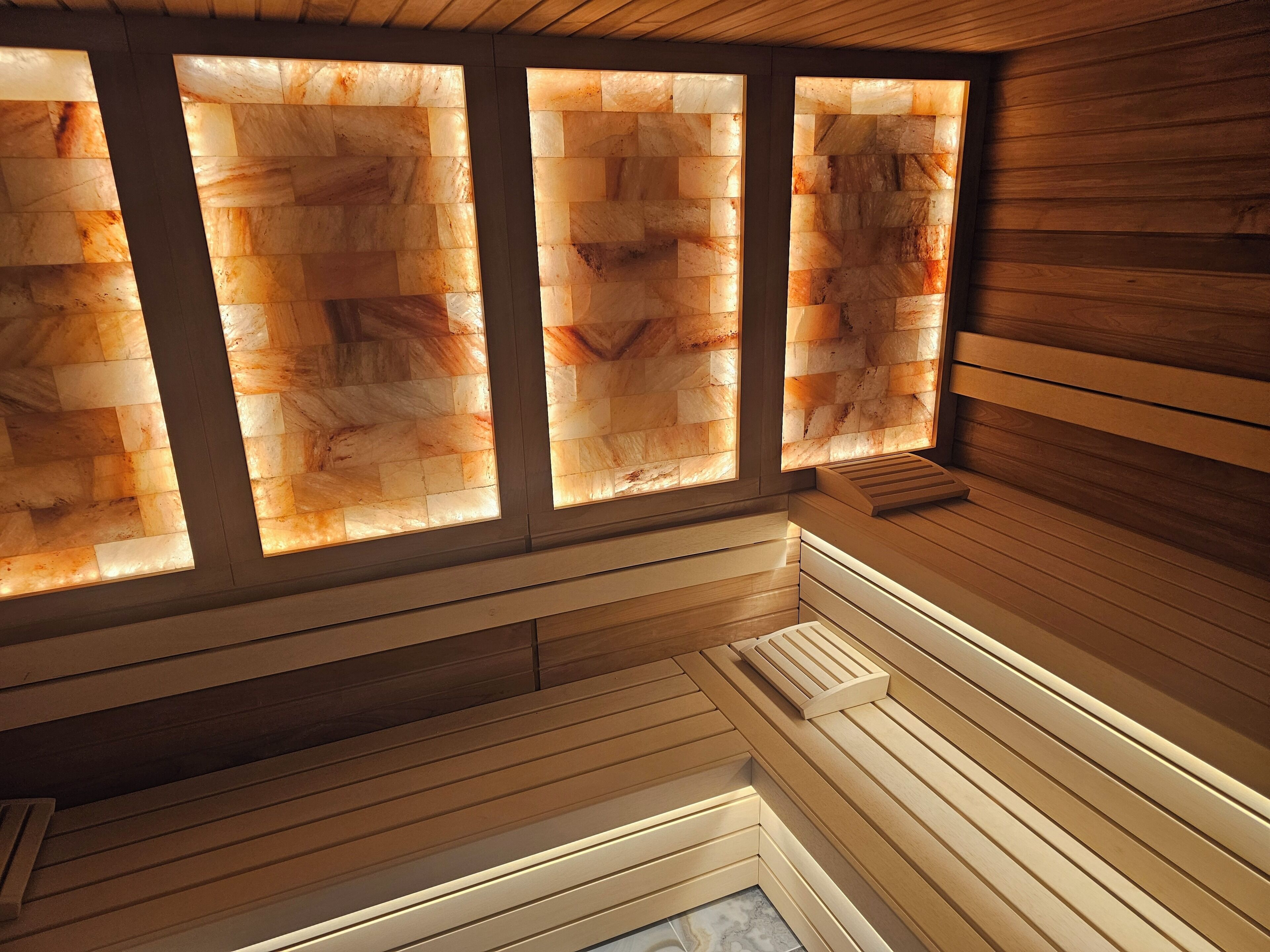 Una sauna con paredes de madera y un banco.