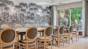 Ein Essbereich mit einer großen Wandmalerei von Bäumen, Holzkreisen und einem für eine Mahlzeit gedecktem Tisch.