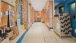 Ein Hotelkorridor mit Holzwandverkleidung, einem Weinkühler und einer Sitzecke.
