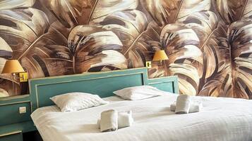 Una habitación de hotel con una cama grande, dos mesitas de noche y un mural en la pared.
