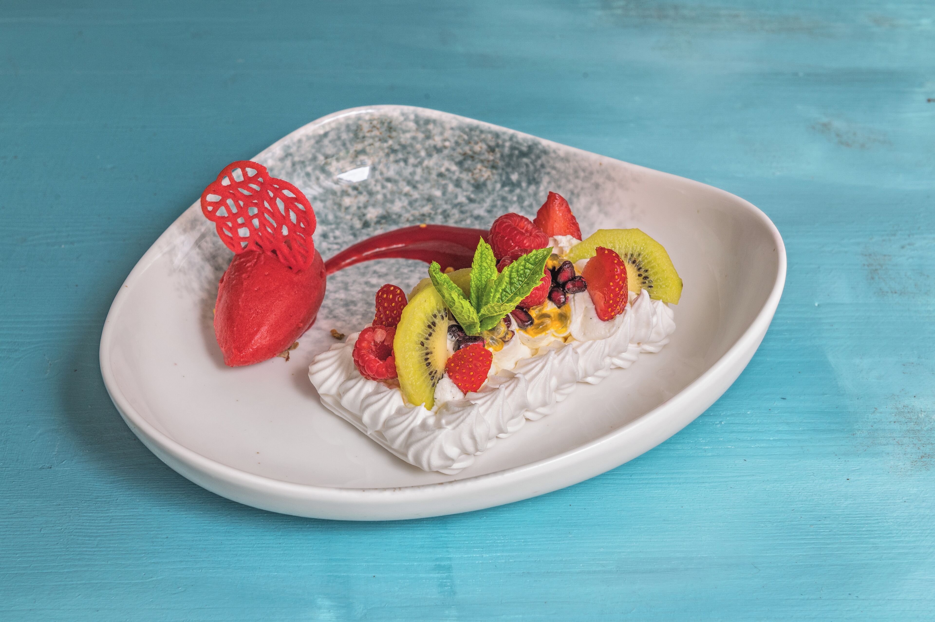 A dessert on a white plate with a blue background.