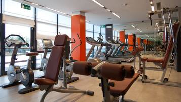 Ein Fitnessstudio mit unterschiedlichen Trainingsgeräten, darunter Laufbänder und Kraftgeräte.