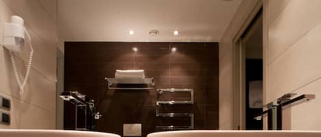 A modern bathroom with two sinks, a hairdryer, towel racks, and a mirror.