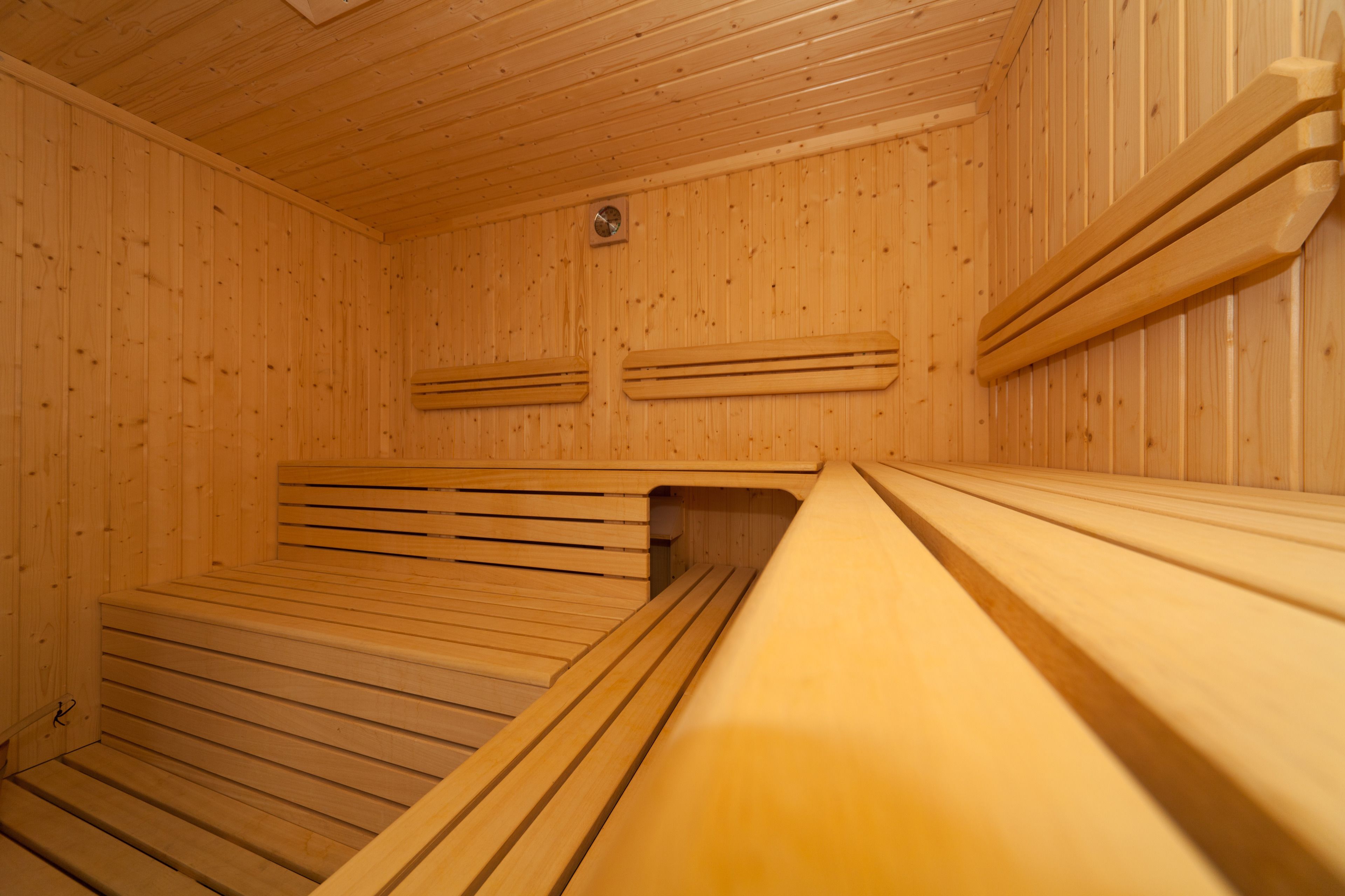 Una sauna con panche in legno e pareti a listelli.