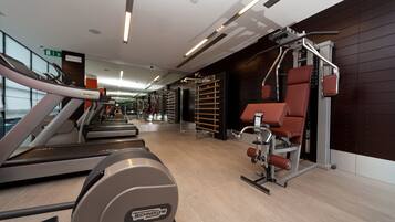 A modern gym with treadmills, a stationary bike, and weightlifting equipment.