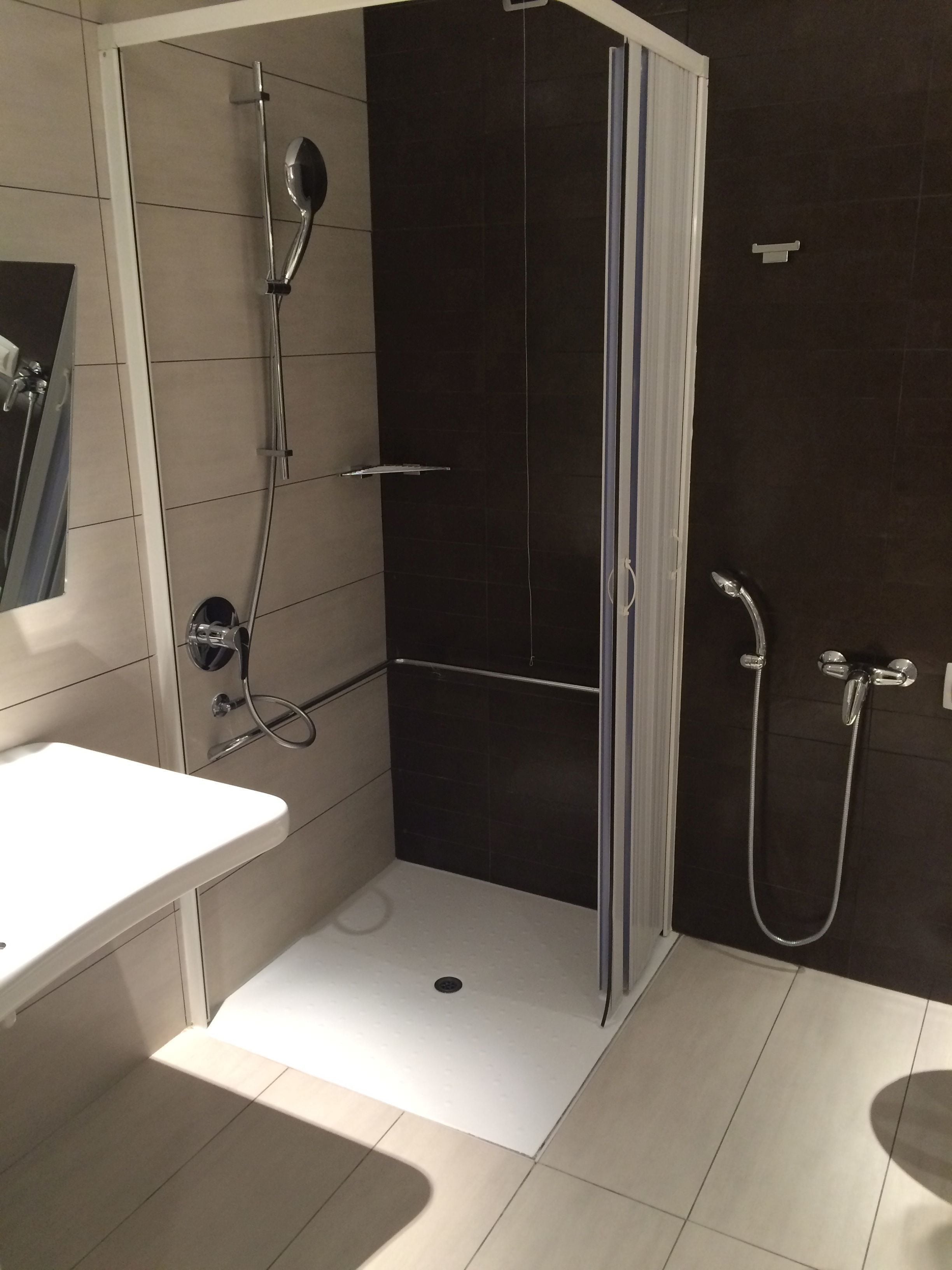 Un baño moderno con cabina de ducha, lavamanos e inodoro.