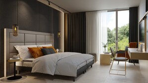 Un dormitorio moderno con una cama grande, mesitas de noche, un escritorio y vistas a zonas verdes por la ventana.