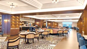 A spacious hotel lobby with multiple dining areas, a reception desk, and a modern ceiling design. - Wyndham Shanghai Hongqiao (Shanghai)