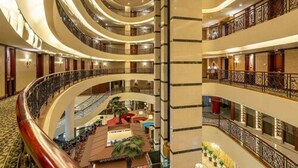 A multi-level hotel interior with a central atrium, balconies, and a variety of seating areas. - Wyndham Shanghai Hongqiao (Shanghai)