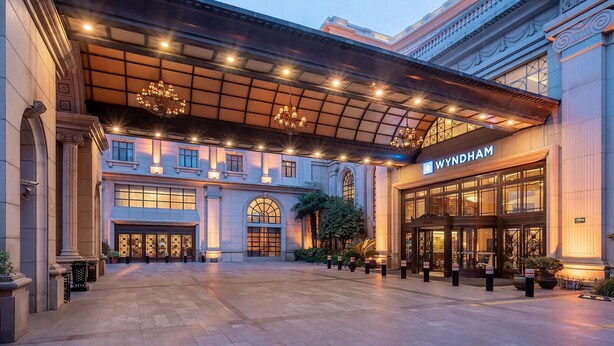 A grand hotel entrance with a covered walkway, large windows, and a prominent Wyndham sign. - Wyndham Shanghai Hongqiao (Shanghai)