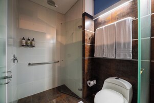 Ein modernes Badezimmer mit Duschkabine, Toilette und Handtuchhalter.