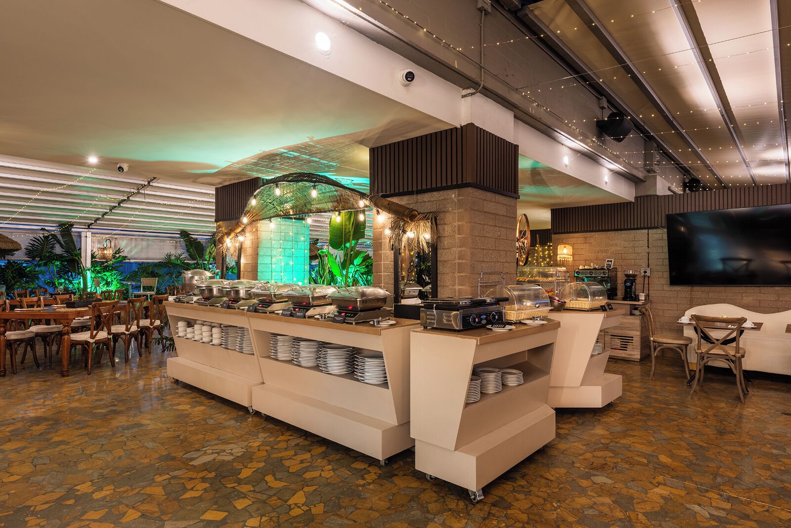 A buffet area with a central island, seating arrangements, and a television screen.