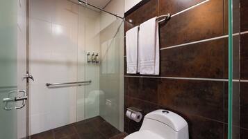 A modern bathroom with a glass shower enclosure, a toilet, and a towel rack.