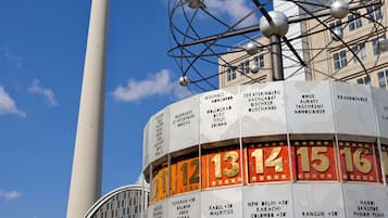 A tower with a spherical observation deck and a large, circular sign with city names and distances.