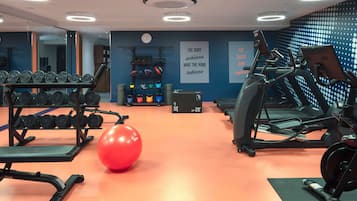 A gym with treadmills, elliptical machines, and free weights.