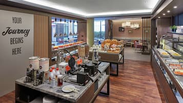 Un espace buffet proposant divers plats et une pancarte sur laquelle on peut lire : « C’est ici que commence votre voyage ».