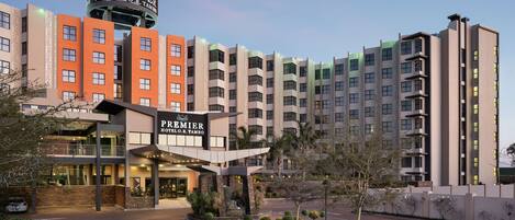 A hotel with multiple buildings, a prominent sign, and a parking area.
