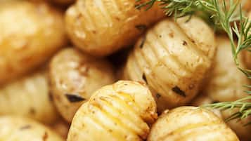 Roasted potatoes garnished with herbs.