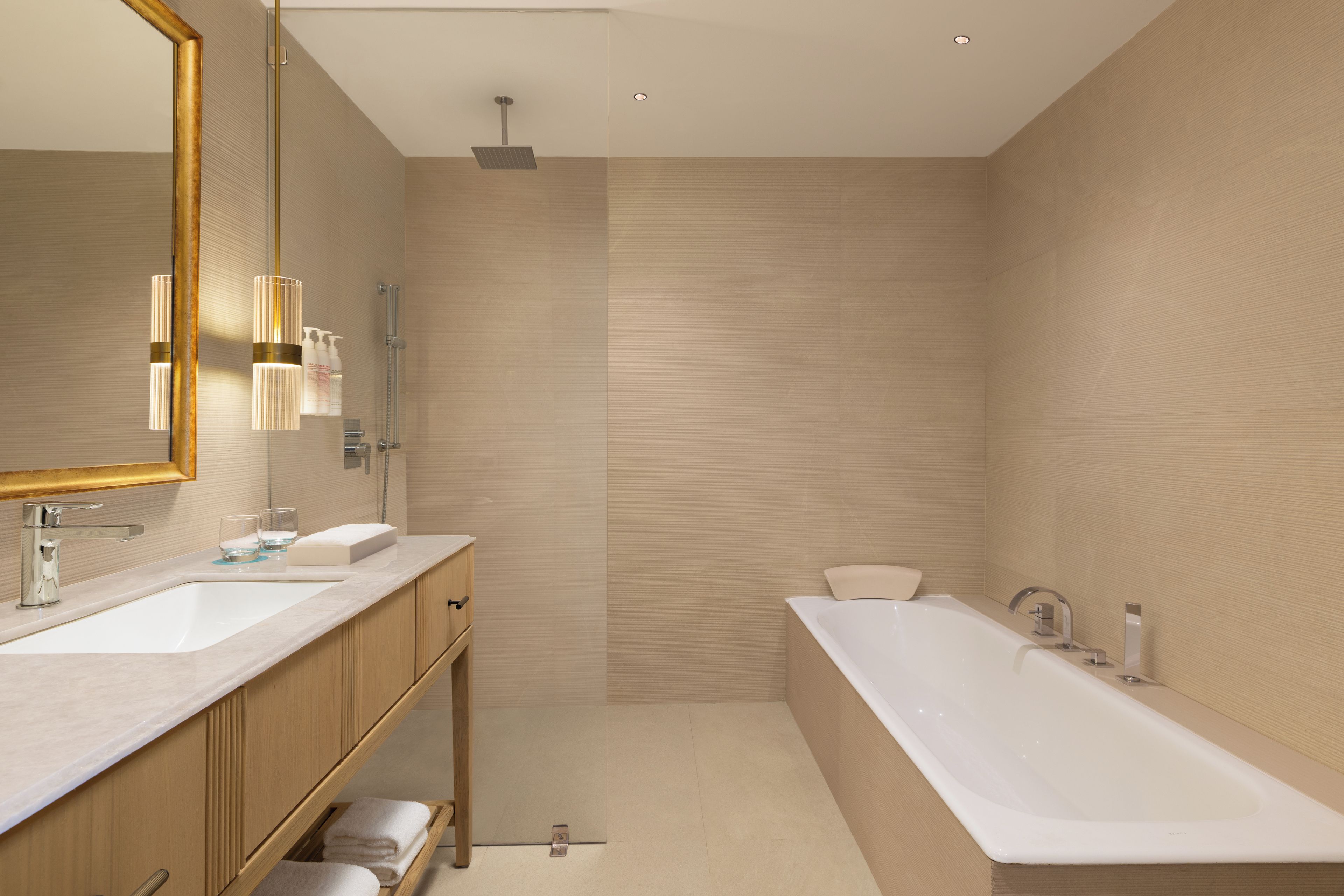 Un baño moderno con dos lavamanos, una bañera grande y una ducha.