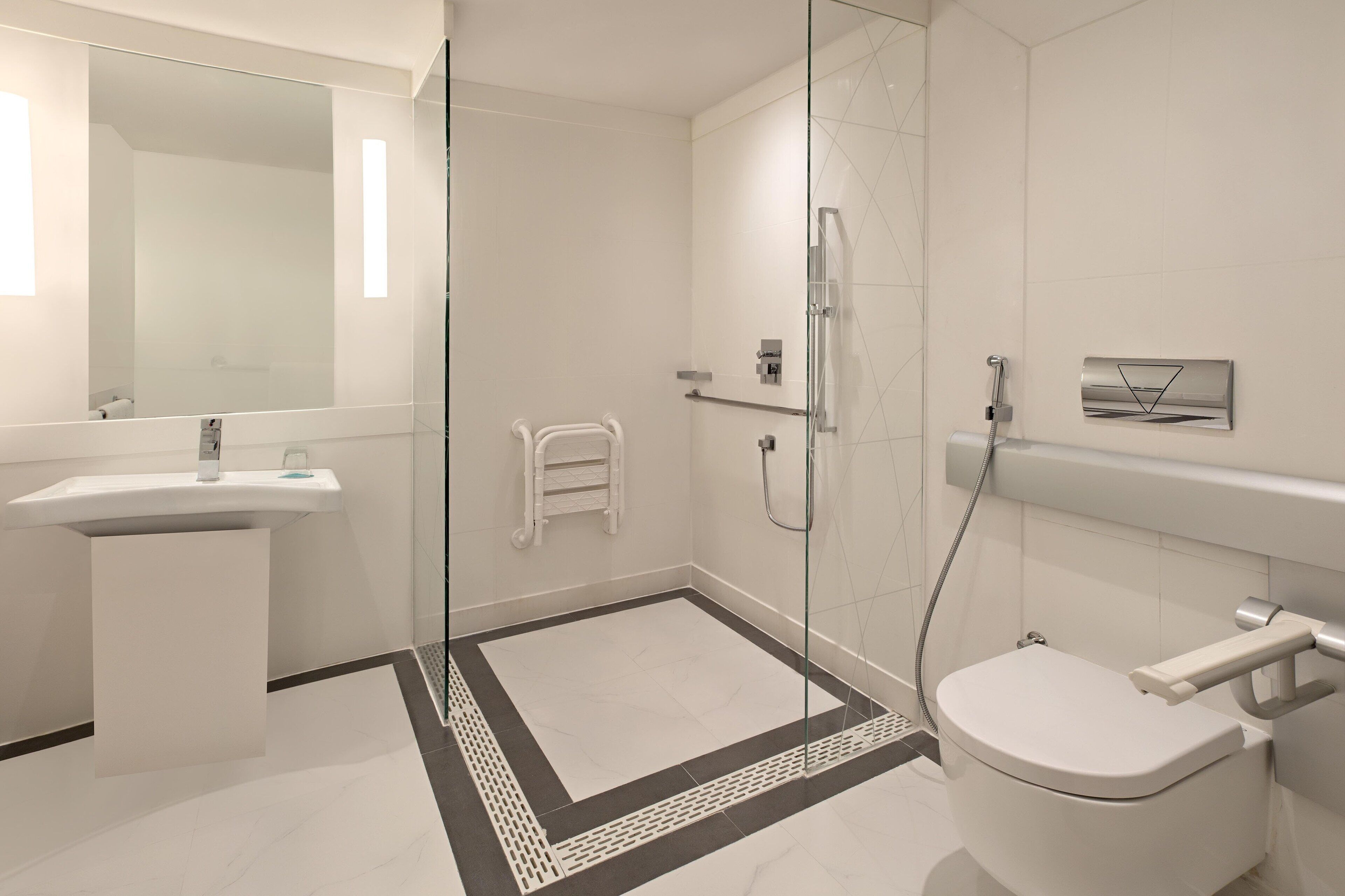 A modern bathroom with a glass-enclosed shower, a white sink, and a toilet.