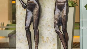 A sculpture of two figures on a pedestal in a public space.