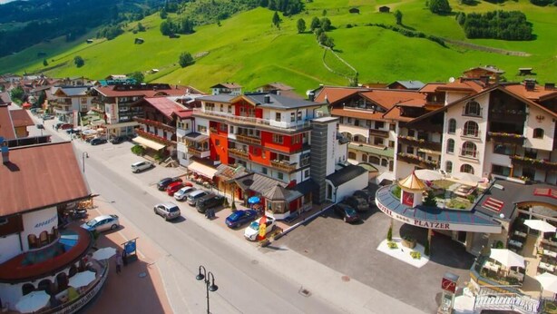 Un hotel con un patio central, varios pisos y vistas a un valle verde.