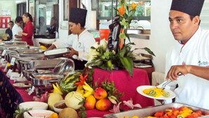 Un buffet allestito con diversi cibi e un elemento decorativo al centro.