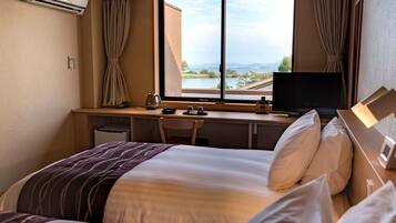 Habitación de hotel con dos camas, un escritorio con televisor, una tetera y vista a un cuerpo de agua.