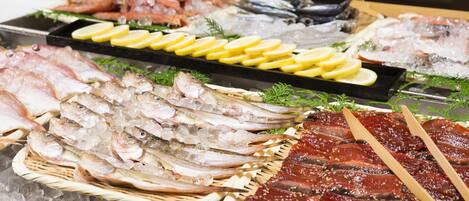 A variety of seafood displayed on ice with wooden tongs.