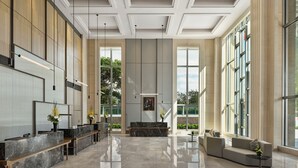 A spacious lobby with a reception desk, seating area, and large windows offering views of greenery. - Shanghai Marriott Hotel Yangpu Riverside (Shanghai)