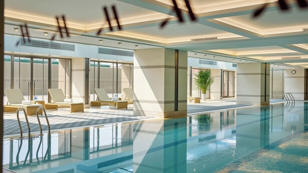 A modern indoor swimming pool with lounge areas, large windows, and a clean, contemporary design. - Shanghai Marriott Hotel Yangpu Riverside (Shanghai)