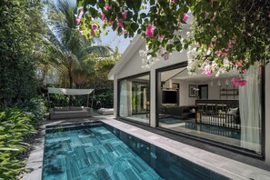 Una casa moderna con piscina, ventanas amplias y un área de patio.