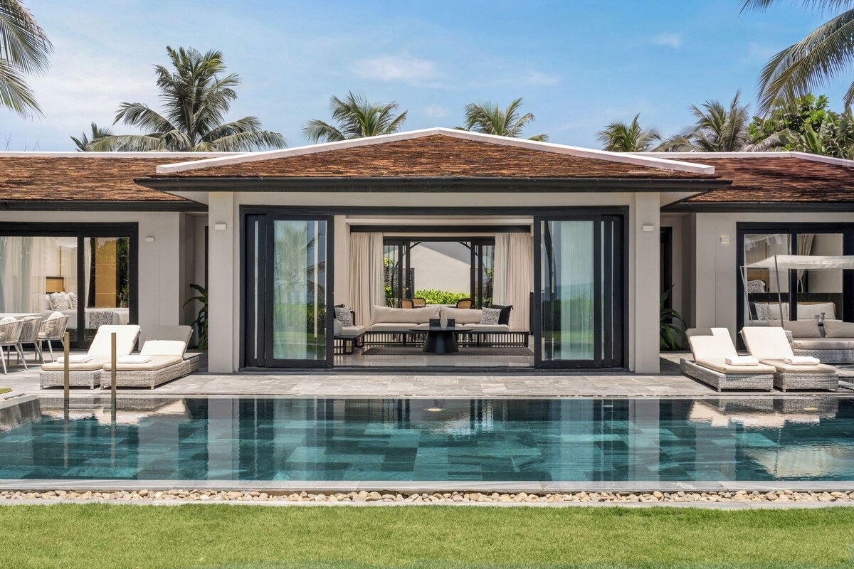 A modern house with a swimming pool, large windows, and outdoor seating.