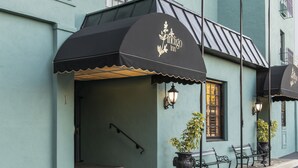 A building with a black awning displaying 'Indigo Inn' and a staircase leading to the entrance.