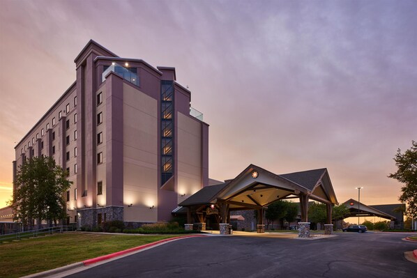 A hotel with a modern design, featuring a large entrance with a covered area and a parking lot. - Cherokee Casino & Hotel West Siloam Springs (Colcord)