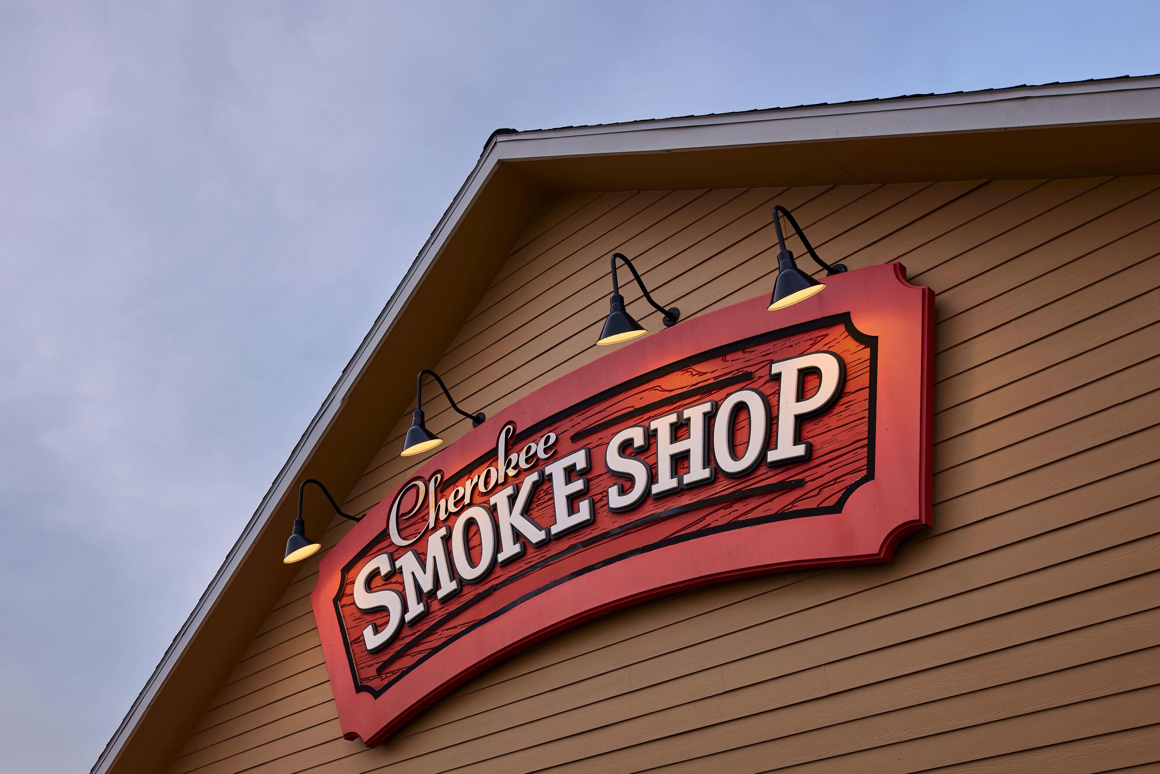 Naamplaatje voor Cherokee Smoke Shop op een gevel.